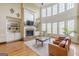 Bright living room boasting a fireplace with stone hearth, built-in shelves, and two-story wall of windows at 217 Brunswick Dr, Tyrone, GA 30290