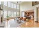 Open-concept living room showcasing tall windows, fireplace, and view into the kitchen and dining area at 217 Brunswick Dr, Tyrone, GA 30290