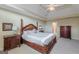 Bright primary bedroom showcases elegant furnishings, tray ceilings, fan, and plush carpeting at 217 Brunswick Dr, Tyrone, GA 30290