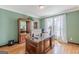 Well-lit office with wood floors, display cabinets, and a glass-topped wooden desk at 217 Brunswick Dr, Tyrone, GA 30290