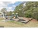 A community playground featuring multiple play structures surrounded by lush greenery and a fenced area at 217 Brunswick Dr, Tyrone, GA 30290