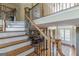 Elegant staircase with wood and iron detailing leads to the upper level, with dining room views at 217 Brunswick Dr, Tyrone, GA 30290