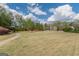 Spacious manicured lawn area with a walking path and trees on a sunny day at 217 Brunswick Dr, Tyrone, GA 30290