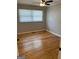 Cozy bedroom with a ceiling fan, hardwood floors, and a window letting in natural light at 1079 Pine Ne St, Conyers, GA 30012