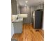 Modern kitchen featuring stainless steel appliances, granite countertops, gray cabinets, and hardwood flooring at 1079 Pine Ne St, Conyers, GA 30012