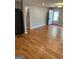 Bright and airy room with hardwood flooring and neutral paint, next to the stainless fridge and the kitchen at 1079 Pine Ne St, Conyers, GA 30012