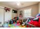 Bedroom with an ABC carpet, toys, TV and a small white crib at 3614 Fairburn Nw Pl, Atlanta, GA 30331