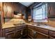 Traditional kitchen featuring brown cabinets, granite countertops, and a stainless steel sink at 3614 Fairburn Nw Pl, Atlanta, GA 30331