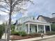 Charming home featuring a covered front porch with stately columns, lush landscaping, and a neatly manicured yard at 11297 Serenbe Ln, Palmetto, GA 30268