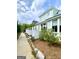 Light-blue two-story home with white trim, complemented by a neatly landscaped side yard and walkway at 11297 Serenbe Ln, Palmetto, GA 30268
