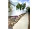 Cement walkway alongside a white fence and decorative rock bed with colorful flowers at 11297 Serenbe Ln, Palmetto, GA 30268