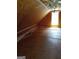 Unfinished attic space with plywood walls and floors featuring a window and ceiling fan at 5003 Samantha Ct, Mcdonough, GA 30252
