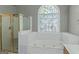 Bright bathroom with vaulted ceiling, arched window, soaking tub, separate shower, and double vanity at 5003 Samantha Ct, Mcdonough, GA 30252