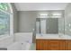 Bathroom featuring a double vanity, soaking tub, large mirror and a window for natural light at 5003 Samantha Ct, Mcdonough, GA 30252