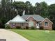 Lovely brick home with lush green lawn, picturesque landscaping and a 'For Sale' sign at 5003 Samantha Ct, Mcdonough, GA 30252