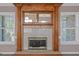 A classic wooden fireplace with mirrored accents and white-framed windows on either side provide a cozy focal point at 5003 Samantha Ct, Mcdonough, GA 30252