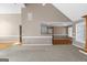 A living space featuring neutral carpet, hardwood, and a kitchen with white cabinetry, divided by a granite-topped bar at 5003 Samantha Ct, Mcdonough, GA 30252