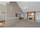 Open-concept living space with fireplace, neutral carpet, hardwood, and a kitchen with white cabinetry and granite bar at 5003 Samantha Ct, Mcdonough, GA 30252