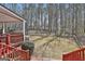 View of the fenced backyard, with trees and manicured landscaping, from the wood deck at 35 Ryans Ct, Sharpsburg, GA 30277