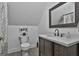 This is a bright bathroom with a modern sink, wood floor, toilet and decorative mirror at 35 Ryans Ct, Sharpsburg, GA 30277