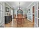 Elegant dining room with hardwood floors, chandelier, and view to a display case and open doorway to the kitchen at 35 Ryans Ct, Sharpsburg, GA 30277