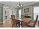 Dining room featuring a hardwood table with chairs, chandelier, open doorway and windows with decorative drapes at 35 Ryans Ct, Sharpsburg, GA 30277