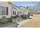 View of a charming white home with a welcoming front porch, green shrubbery, and gray stone accents at 35 Ryans Ct, Sharpsburg, GA 30277