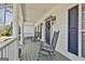 Inviting front porch featuring rocking chairs and a charming entrance with decorative wreath and wall lanterns at 35 Ryans Ct, Sharpsburg, GA 30277