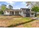 A charming home is showcased with a stone chimney and inviting porch swing on a lush green lawn at 205 Raintree Bnd, Peachtree City, GA 30269