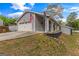 Charming home featuring a two-car garage and American flags, set against a backdrop of mature trees and sky at 205 Raintree Bnd, Peachtree City, GA 30269
