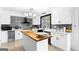 Bright kitchen features white cabinets, a butcher block island, and sleek black hardware at 205 Raintree Bnd, Peachtree City, GA 30269