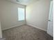A simple bedroom with neutral carpet, a window, and a white door at 661 Outlook Way, South Fulton, GA 30349