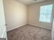 A simple bedroom with neutral carpet, a window, and a white door at 661 Outlook Way, South Fulton, GA 30349