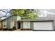 Inviting home with stone accents, a well-manicured lawn, and an attached garage at 1475 Woodington Cir, Lawrenceville, GA 30044