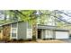 Charming home featuring stone accents, light green siding, a well-maintained lawn, and an attached garage at 1475 Woodington Cir, Lawrenceville, GA 30044