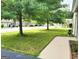 Well-maintained lawn in the front yard with beautiful trees, sidewalk, and view of the neighbor's home at 1475 Woodington Cir, Lawrenceville, GA 30044