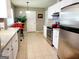 The bright kitchen includes stainless steel appliances, white cabinets, and tiled floors at 1475 Woodington Cir, Lawrenceville, GA 30044