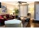 Cozy living room with hardwood floors, a red leather couch, recliner chairs, area rug, and lots of natural light at 1475 Woodington Cir, Lawrenceville, GA 30044