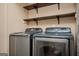 Laundry room with a modern washer and dryer and wooden shelves at 4691 Garden Hills Ct, Stone Mountain, GA 30083