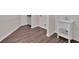 Finished basement with wood-look flooring, featuring a utility sink with a white base and an open shelving system at 250 Stonecreek Pkwy, Covington, GA 30016