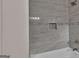 Close-up showcasing a tiled shower featuring gray patterned tiles, a built-in niche, and modern fixtures for a luxurious feel at 250 Stonecreek Pkwy, Covington, GA 30016