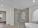 Bright bathroom with shower, tub and window alcove featuring modern tile and finishes at 250 Stonecreek Pkwy, Covington, GA 30016