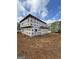 The house is under construction; house wrap is visible on the two story home with bare red clay property and lumber debris at 523 Courthouse Park Dr, Temple, GA 30179