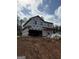 Two story home under construction with visible house wrap, a garage, and lumber strewn about the red clay property at 523 Courthouse Park Dr, Temple, GA 30179