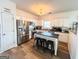 Bright kitchen featuring stainless steel appliances, white cabinets, island with bar stools and wood flooring at 304 Commons Dr, Jonesboro, GA 30236