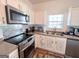 Well-lit kitchen featuring stainless steel appliances, updated countertops and white cabinetry at 304 Commons Dr, Jonesboro, GA 30236
