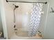 Shower-tub combo with white tile and a modern shower head and curtain at 304 Commons Dr, Jonesboro, GA 30236