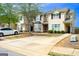 Street view of well-maintained townhomes, featuring a neat driveway, landscaping and mature trees at 304 Commons Dr, Jonesboro, GA 30236