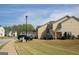 A neighborhood street showcases well-kept townhomes, each with unique architectural details and neatly manicured front lawns at 304 Commons Dr, Jonesboro, GA 30236