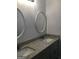 Bathroom featuring double sinks with granite countertops and decorative oval mirrors at 25 Dove Pt, Covington, GA 30016